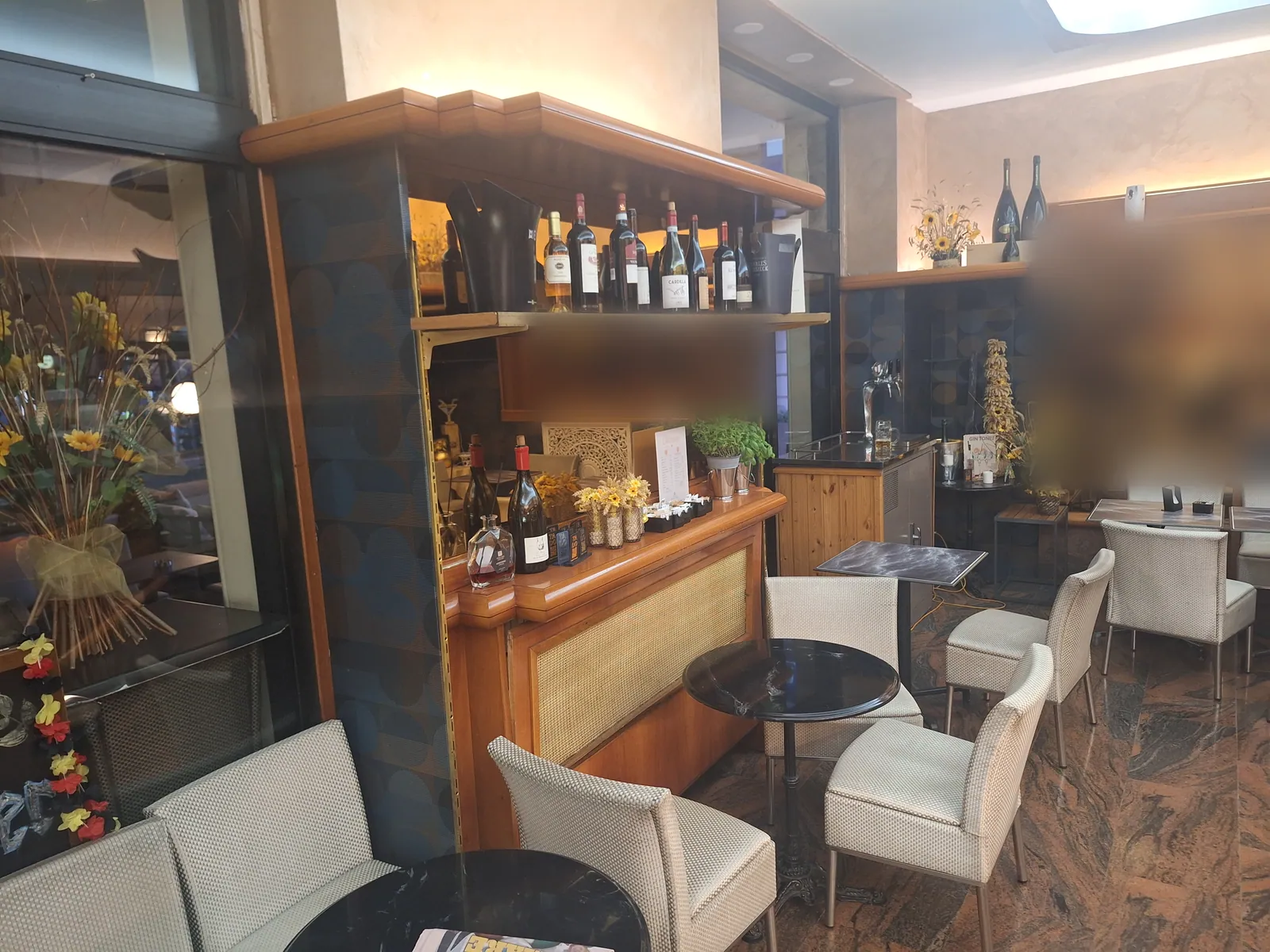 L'angolo dei vini e i tavolini vicino alla vetrina